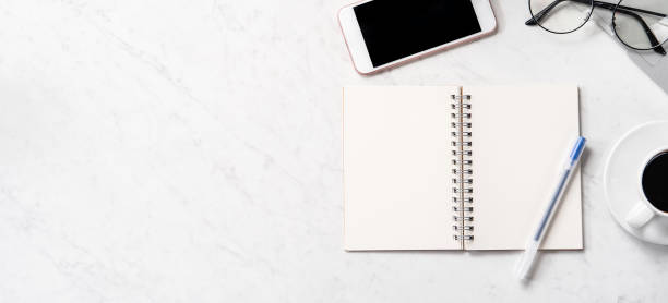 istock Stylized marble office working desk with smartphone, laptop, glasses and coffee, workspace design, mock up, topview, flatlay, copyspace, closeup 1126090248