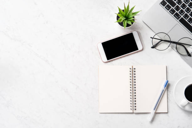 istock Stylized marble office working desk with smartphone, laptop, glasses and coffee, workspace design, mock up, topview, flatlay, copyspace, closeup 1126090264