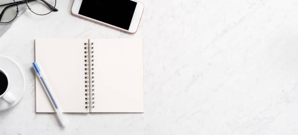 istock Stylized marble office working desk with smartphone, laptop, glasses and coffee, workspace design, mock up, topview, flatlay, copyspace, closeup 1126090304