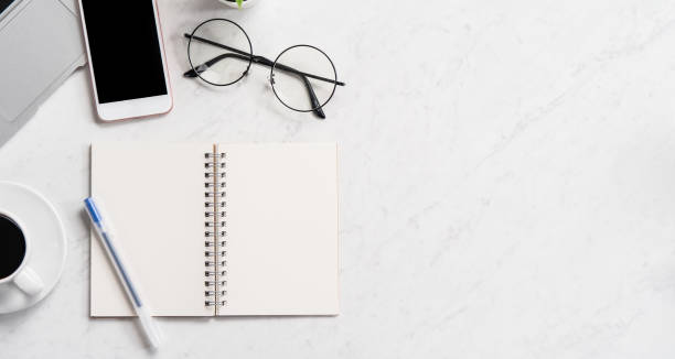 istock Stylized marble office working desk with smartphone, laptop, glasses and coffee, workspace design, mock up, topview, flatlay, copyspace, closeup 1126090327