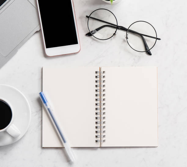 istock Stylized marble office working desk with smartphone, laptop, glasses and coffee, workspace design, mock up, topview, flatlay, copyspace, closeup 1126090381