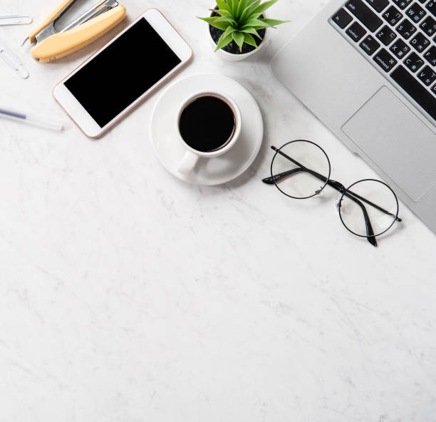 istock Stylized marble office working desk with smartphone, laptop, glasses and coffee, workspace design, mock up, topview, flatlay, copyspace, closeup 1126090397