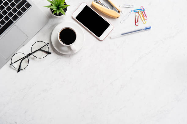 istock Stylized marble office working desk with smartphone, laptop, glasses and coffee, workspace design, mock up, topview, flatlay, copyspace, closeup 1126090471