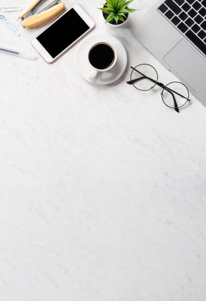 istock Stylized marble office working desk with smartphone, laptop, glasses and coffee, workspace design, mock up, topview, flatlay, copyspace, closeup 1126090545