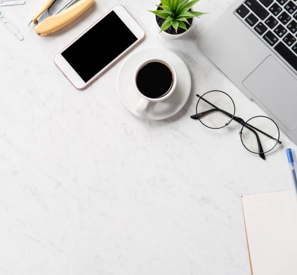 istock Stylized marble office working desk with smartphone, laptop, glasses and coffee, workspace design, mock up, topview, flatlay, copyspace, closeup 1126090600