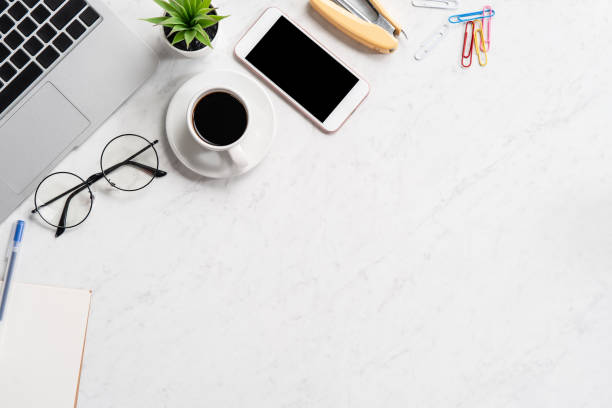 istock Stylized marble office working desk with smartphone, laptop, glasses and coffee, workspace design, mock up, topview, flatlay, copyspace, closeup 1126090936