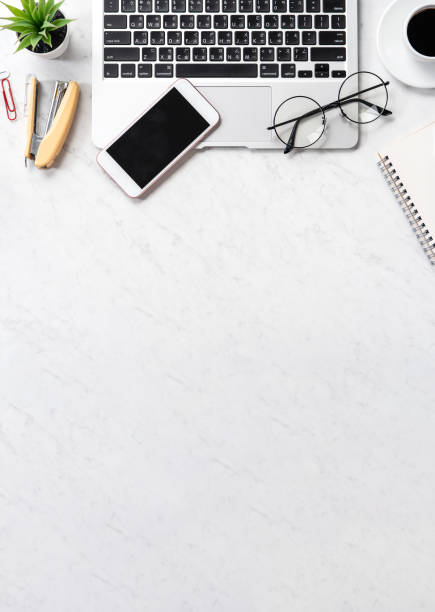 istock Stylized marble office working desk with smartphone, laptop, glasses and coffee, workspace design, mock up, topview, flatlay, copyspace, closeup 1126091287