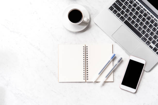 istock Stylized marble office working desk with smartphone, laptop, glasses and coffee, workspace design, mock up, topview, flatlay, copyspace, closeup 1126091687