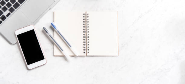 istock Stylized marble office working desk with smartphone, laptop, glasses and coffee, workspace design, mock up, topview, flatlay, copyspace, closeup 1126091691