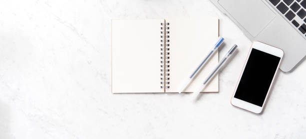 istock Stylized marble office working desk with smartphone, laptop, glasses and coffee, workspace design, mock up, topview, flatlay, copyspace, closeup 1126091743