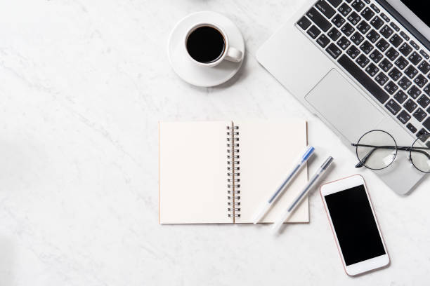 istock Stylized marble office working desk with smartphone, laptop, glasses and coffee, workspace design, mock up, topview, flatlay, copyspace, closeup 1126091752