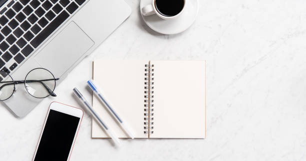 istock Stylized marble office working desk with smartphone, laptop, glasses and coffee, workspace design, mock up, topview, flatlay, copyspace, closeup 1126091818