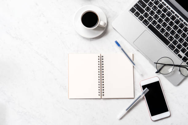 istock Stylized marble office working desk with smartphone, laptop, glasses and coffee, workspace design, mock up, topview, flatlay, copyspace, closeup 1126091894