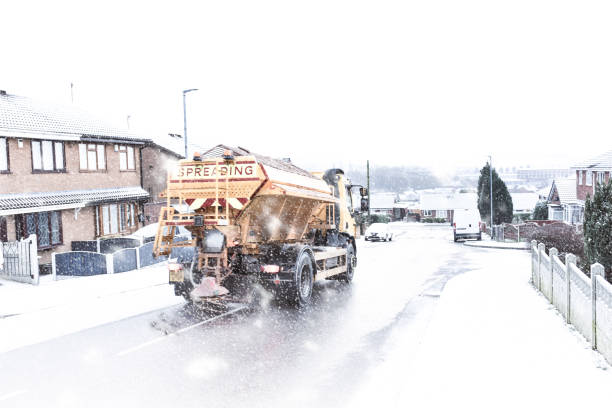 un camión de sal por nevadas, apretando el peligroso hielo y la nieve cubrieron carreteras. black ice, malas condiciones de camino (tiro con un desenfoque de movimiento leve) - hacer muecas fotografías e imágenes de stock