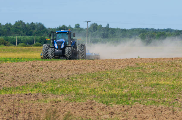 istock Front view of the tractor plows the field with swirling dust 1126093331