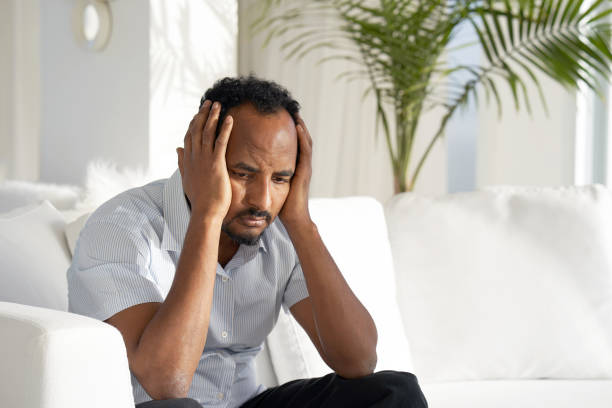 istock sad african man lies on the bed. 1126093638