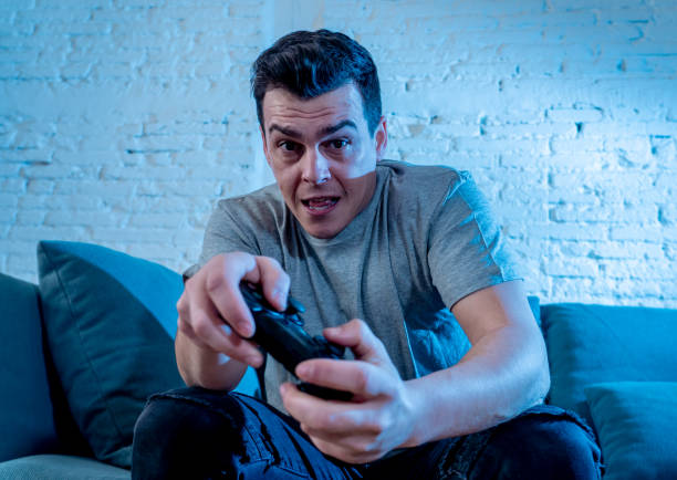 istock Portrait of young student man spending time playing video games using wireless remote joystick with freak intense happy face having fun in Male game addiction to console play station and video. 1126094675