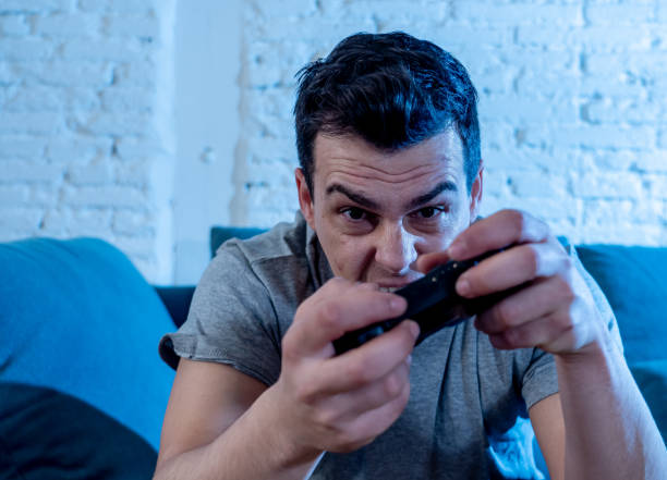istock Portrait of young student man spending time playing video games using wireless remote joystick with freak intense happy face having fun in Male game addiction to console play station and video. 1126094721