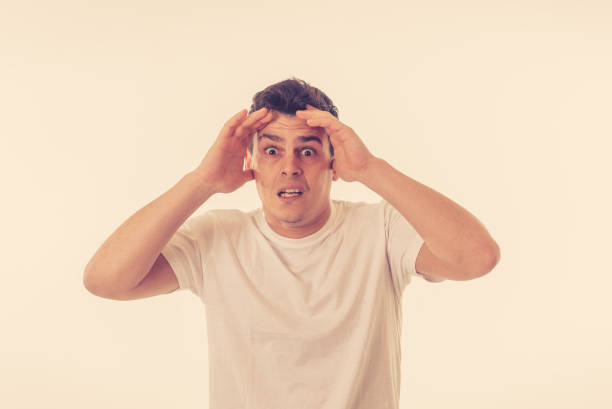 istock Portrait of young man in shock with a scared face expression making frightened gestures in People, human emotions, feelings and horror facial expression concept. Isolated on white background. 1126094778