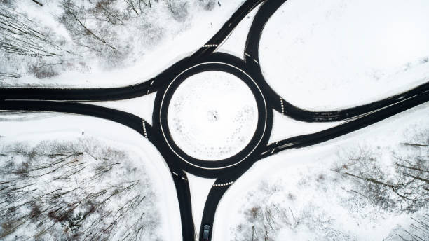 istock Traffic circle and road through wintery forest 1126097345
