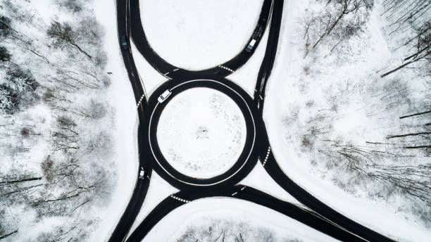 istock Traffic circle and road through wintery forest 1126097378