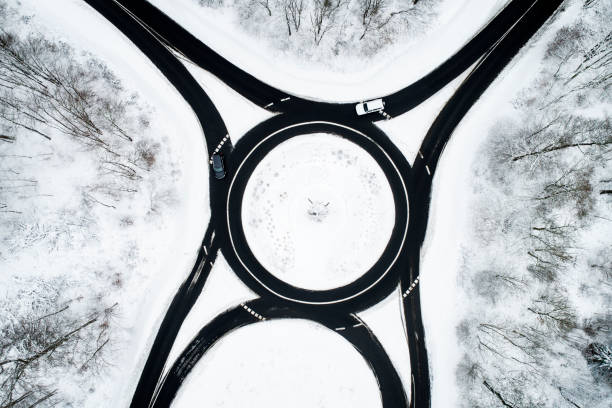 istock Traffic circle and road through wintery forest 1126097393