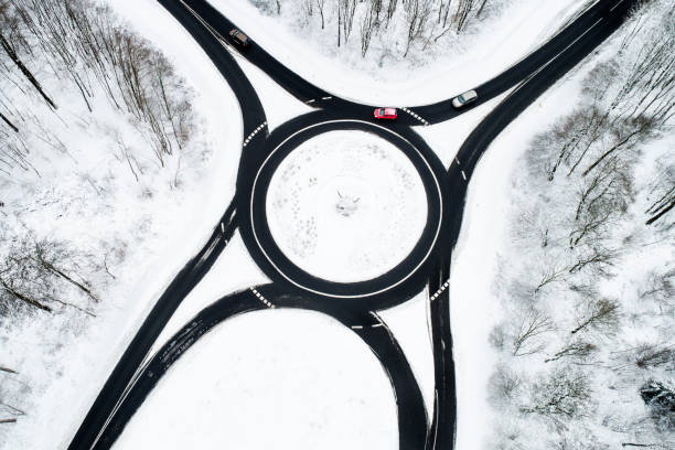 istock Traffic circle and road through wintery forest 1126097409