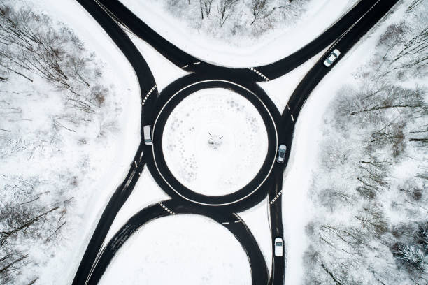 istock Traffic circle and road through wintery forest 1126097414
