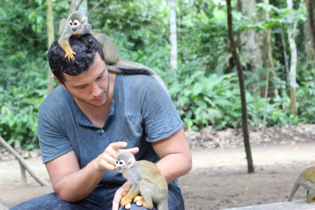 Man training a group of titi monkeys