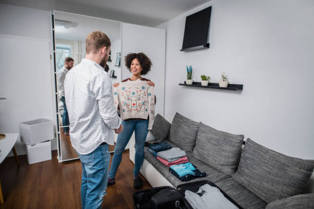 istock Young couple putting clothes in the suitcase 1126101033