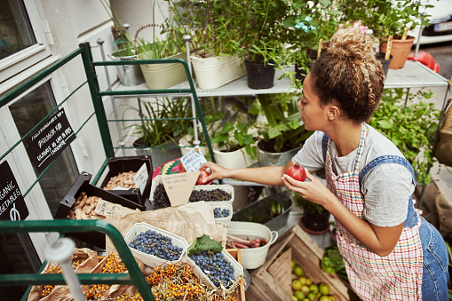 Cropped shot of an attractive young woman working in her self-owned farm stall