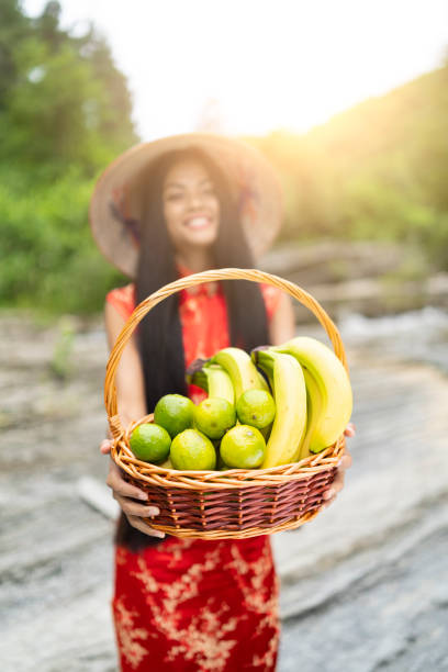 istock Young woman holding a baset with limes and bananas 1126101706