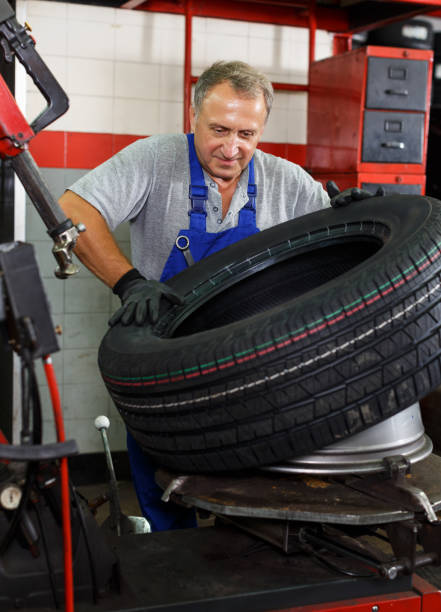 istock mechanician removing tire from wheel disc 1126103086