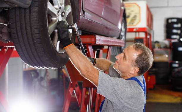istock Elderly man mechanic engaged in replacement of car wheel in auto workshop 1126103110