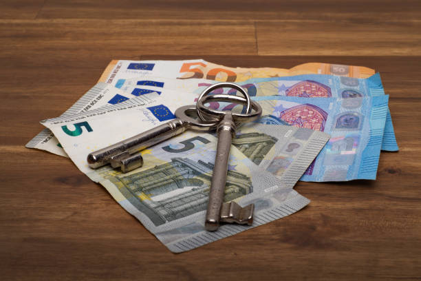 istock Euro bills on the table with a key, on the brown table 1126104341