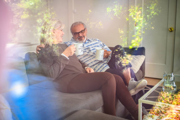 heureux couple de personnes âgées bénéficiant du café sur le canapé - senior adult comfortable relaxation latin american and hispanic ethnicity photos et images de collection