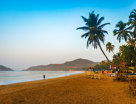 Palolem Beach, Goa, India - March, 08 2023: Stock photo showing rows of outdoor seating and tables of a restaurant on Palolem Beach, Goa, South India.