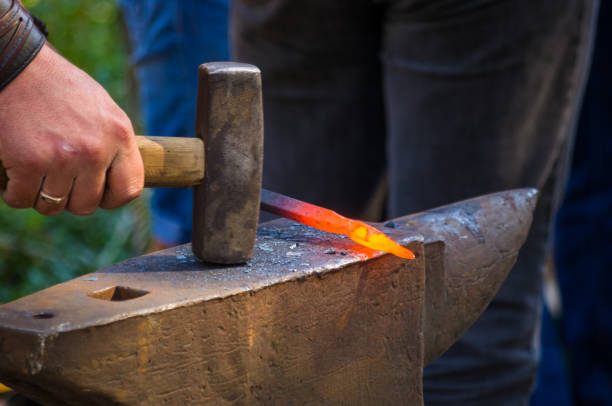 istock blacksmith performs the forging of hot glowing metal on the anvil 1126116415