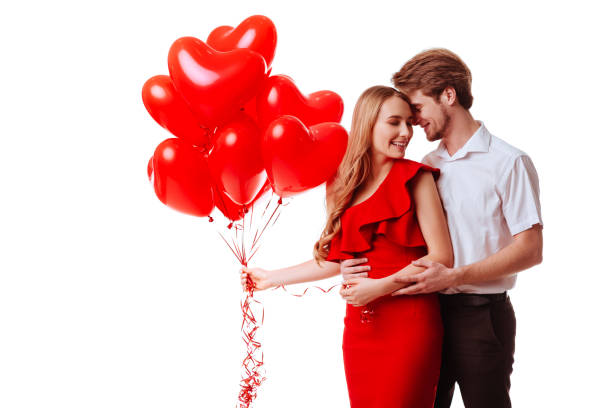istock Kissing couple posing on white background with balloons heart. 1126117521