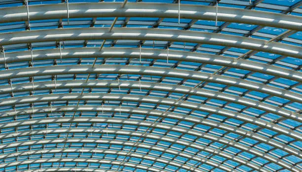 Glass and Metal Roof Structure shot with a sense of depth and perspective. Blue sky showing through.