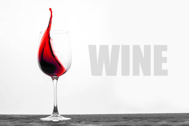 The red wine in the glass splashes in motion on a white background. Stylish design drink card with text