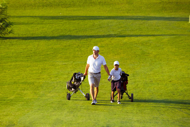 istock man with his son golfers walking on golf course 1126125498