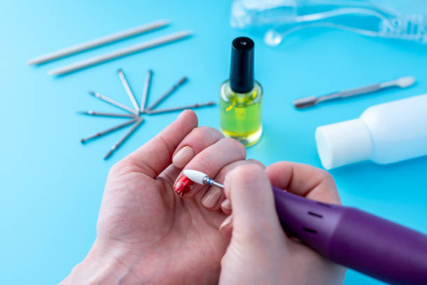 istock Female manicurist doing a professional manicure hardware using milling cutter on the background of the tools 1126125592
