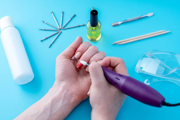 istock Female manicurist doing a professional manicure hardware using milling cutter on the background of the tools 1126125596