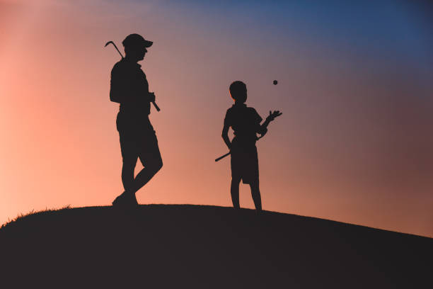 istock man with his son golfers silhouette 1126125663