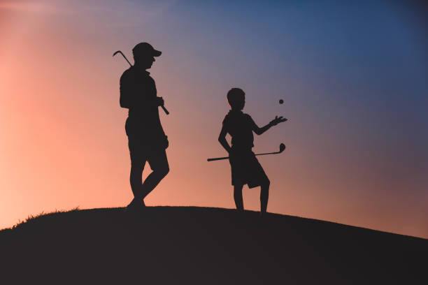 istock man with his son golfers silhouette 1126125669
