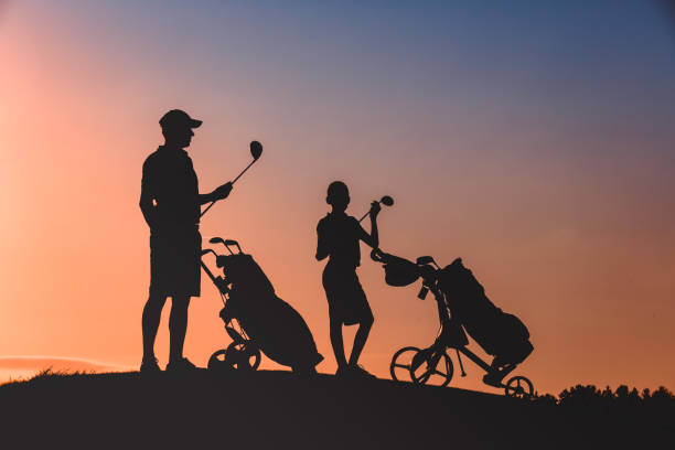 istock man with his son golfers silhouette 1126125677