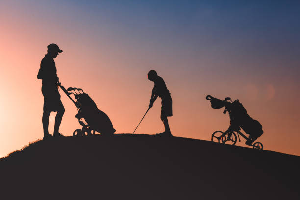 istock man with his son golfers silhouette 1126125681