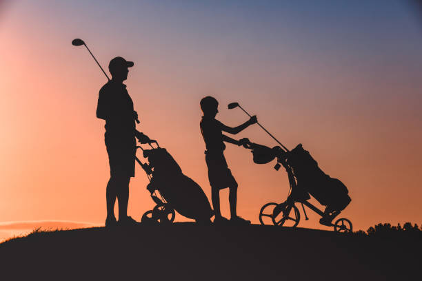 istock man with his son golfers silhouette 1126125682