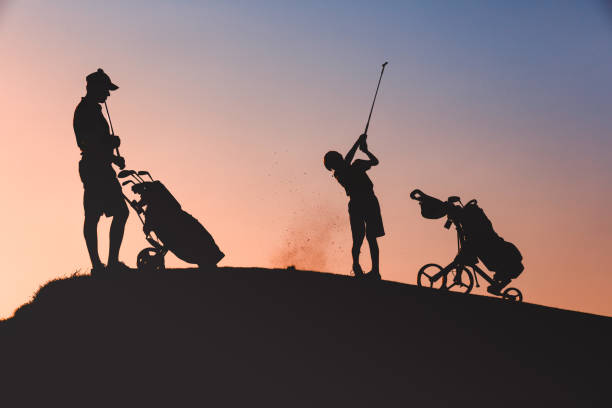 istock man with his son golfers silhouette 1126125695